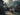 Balinese-style outer temple courtyard and visitors in modest dress — AI visual study, not a named temple.